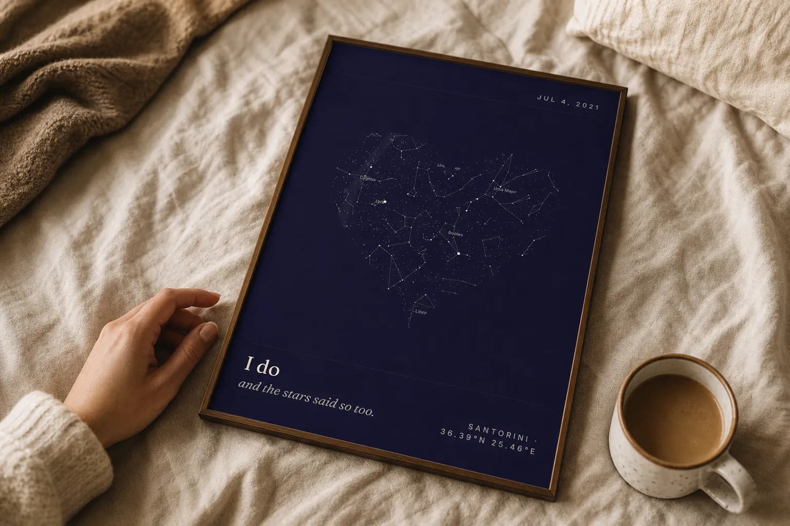 A framed SkyWhen star map print resting on linen bedding in morning light